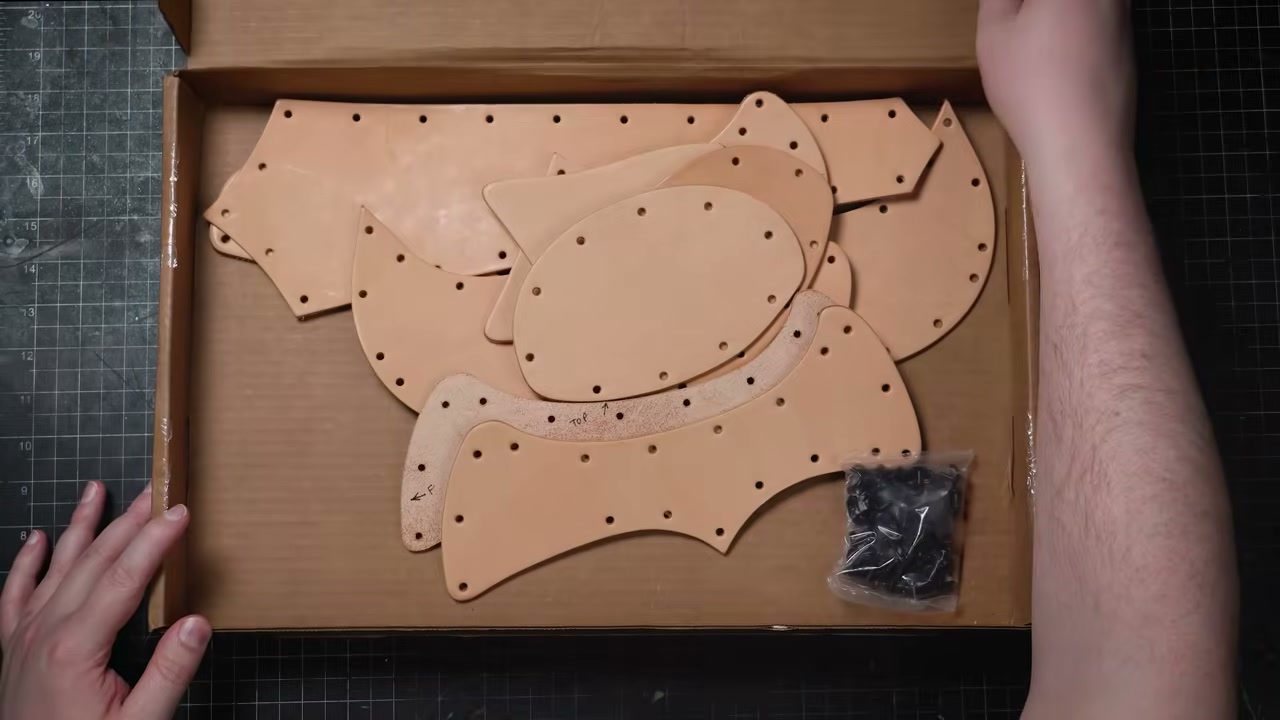 Warrior Helmet Build Guide: A Real Leather Helmet with Just a Hammer 2 Warrior Helmet kit box with pre-cut lettered leather pieces and a bag of double-cap rivets
