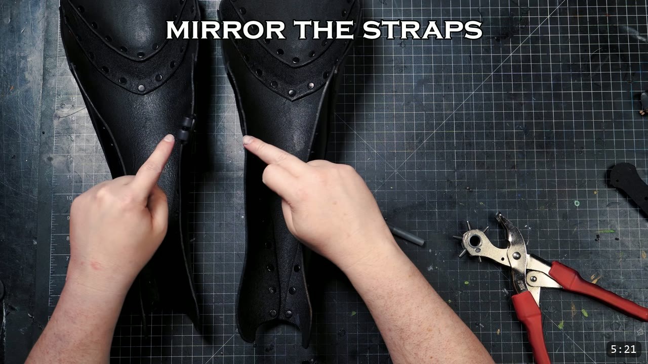 Beginner Leather Greaves Build Guide: The Easy Leg Armor to Start With 12 the finished pair of formed black greaves standing on the mat, hands pointing to the mirrored buckle-strap positions on each