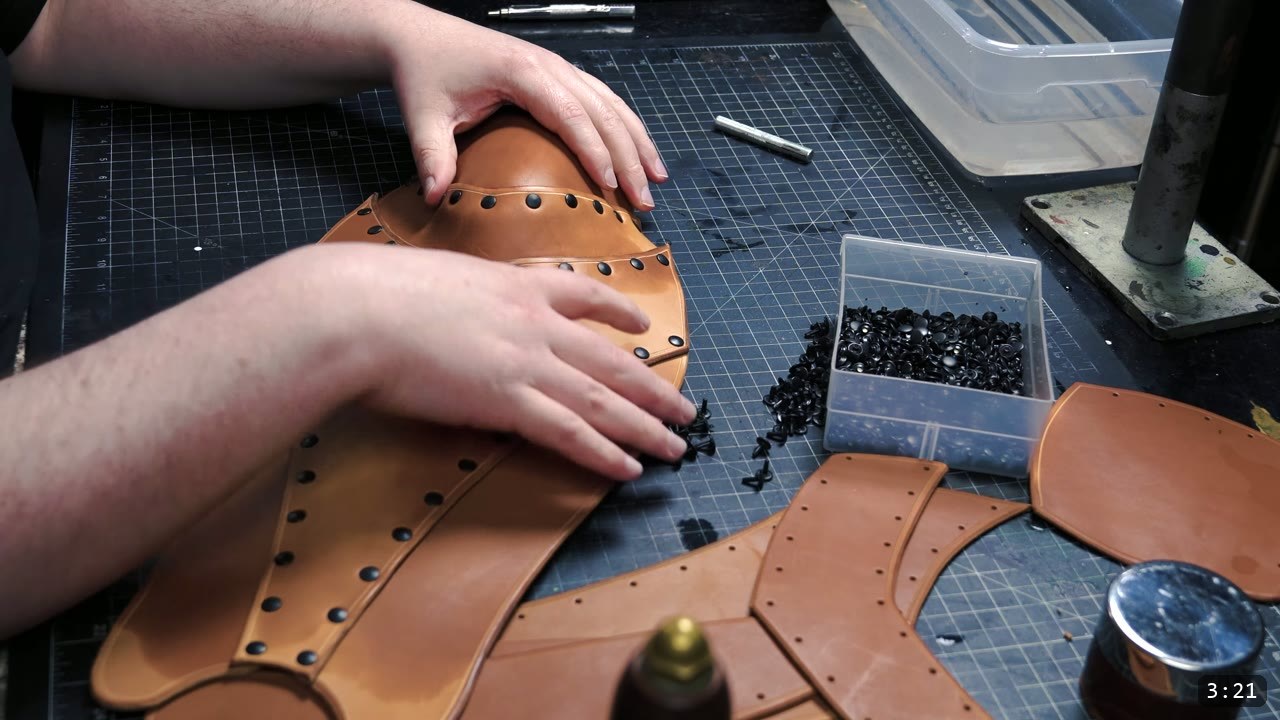 Beginner Leather Greaves Build Guide: The Easy Leg Armor to Start With 7 hands pressing and refining the domed knee area of the formed tan greave, a brass rivet setter and a box of rivets nearby