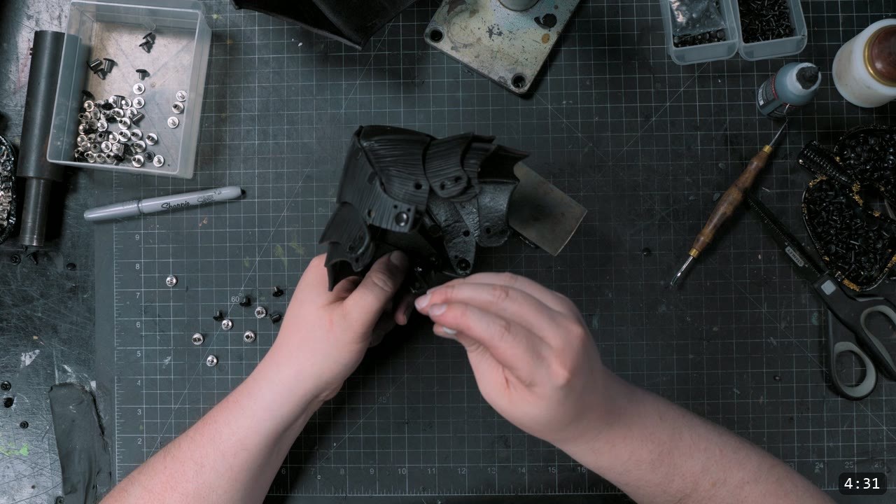 the four articulating lames assembled around the dyed-black elbow cop