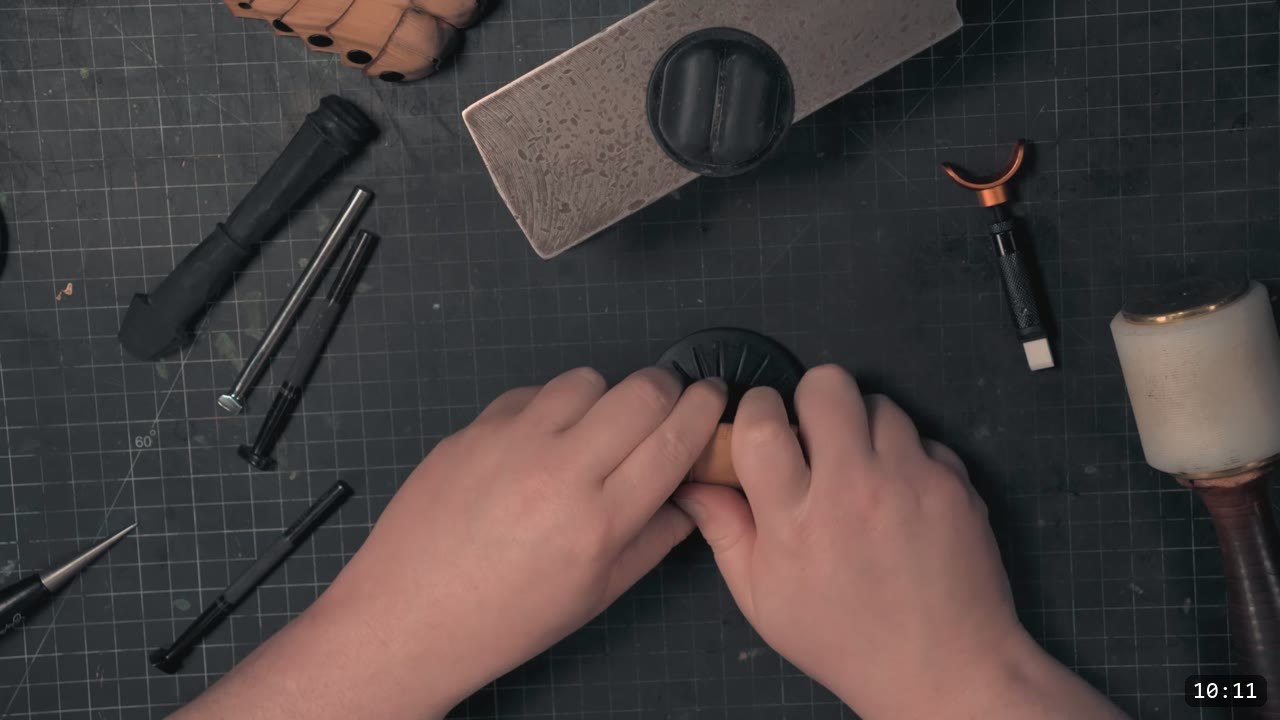 Berserk Gauntlets Build Guide: The Leather Version, Step by Step 9 hands pressing a damp tan leather piece over a small raised 3D-printed dome form on a cutting mat