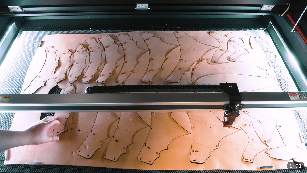 Berserk Leg Armor Build Guide: Articulated Leather Cuisses, Knees, and Greaves 2 Berserker leg armor pieces laser cut from a full sheet of vegetable tan leather on a large laser bed, with decorative flute lines already engraved