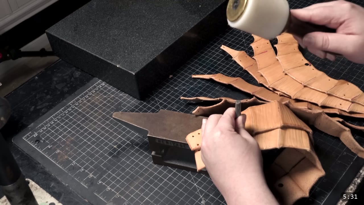 setting a rivet on the overlapping tan core plates with a rivet setter over a small forming stick