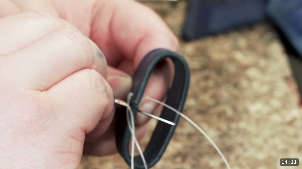 Fantasy Spaulders Build Guide: Leather Shoulder Armor from a Flat Pattern 13 fingers holding a small dark keeper loop being hand-stitched closed with a needle and light thread