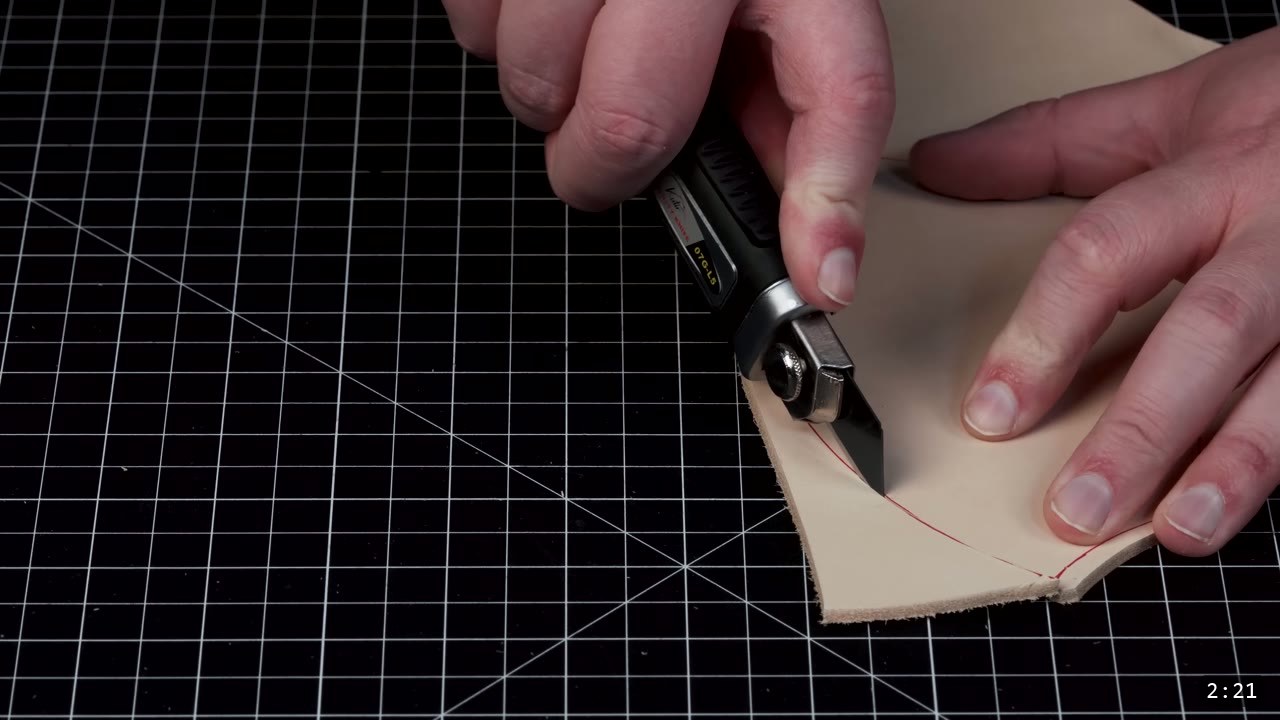 Fantasy Spaulders Build Guide: Leather Shoulder Armor from a Flat Pattern 3 a utility knife cutting along a red drawn line on a piece of tan vegetable-tan leather on a gridded cutting mat