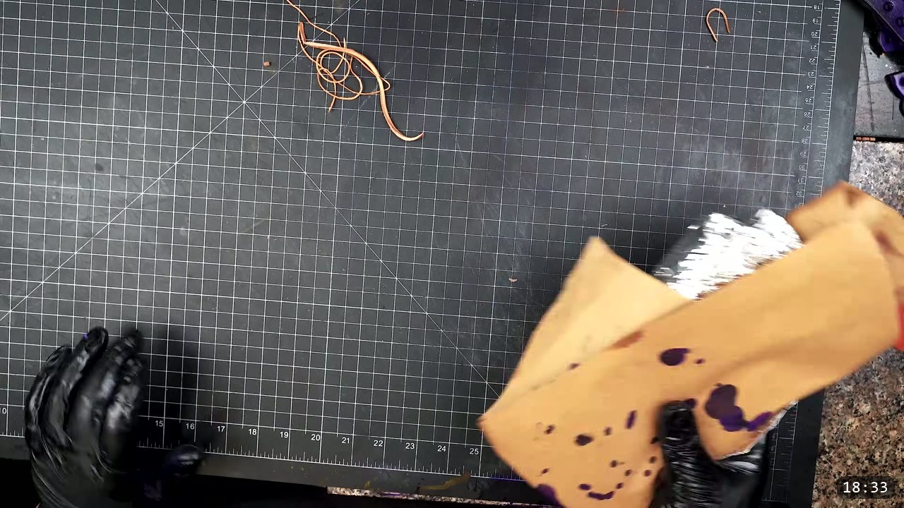 Female Leather Breastplate Build Guide: Articulated Fantasy Armor, Step by Step 12 offloading a brush onto scrap kraft paper, with a gloved hand on a black cutting mat