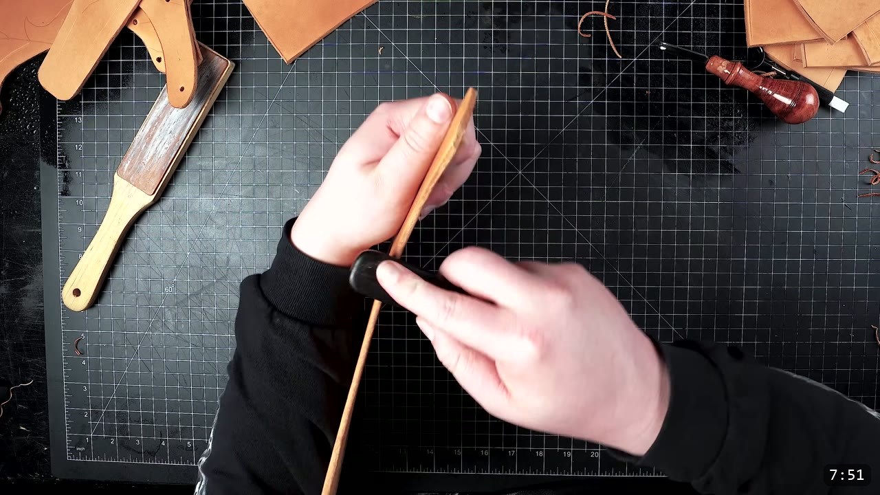 Female Leather Breastplate Build Guide: Articulated Fantasy Armor, Step by Step 7 edge-finishing a cut leather piece with a wooden slicker, a burnishing paddle and an edge tool resting on the mat