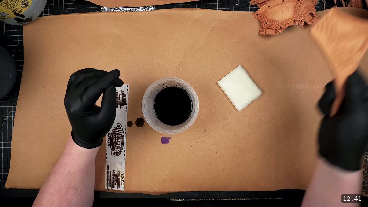 Female Leather Breastplate Build Guide: Articulated Fantasy Armor, Step by Step 9 an overhead dye station with black nitrile gloves, a tub of dark purple dye, a white sponge, and a Weaver Leather Supply dauber