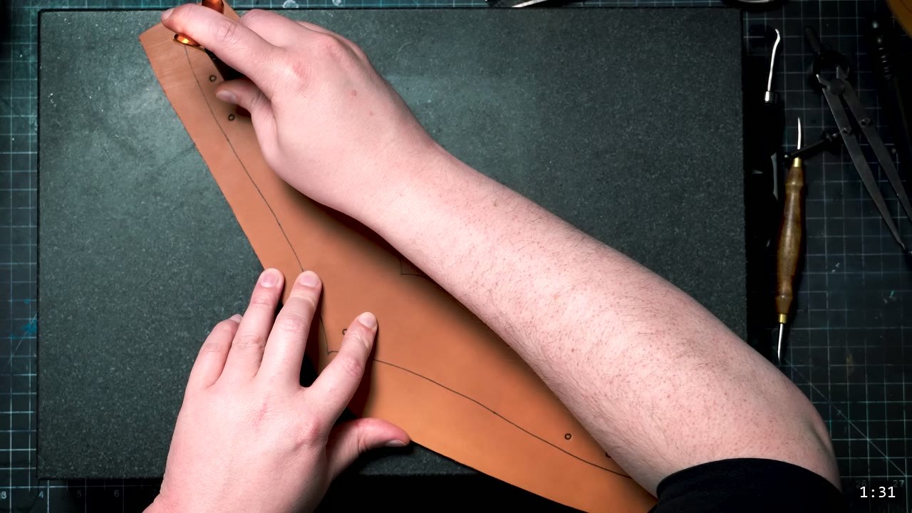Leather Elven Helmet Build Guide: Visor, Comb, Tail, and a Green Metallic Finish 3 hands tracing and separating a large tan leather piece on a dark stone slab, with wing dividers and hand tools laid out to the side