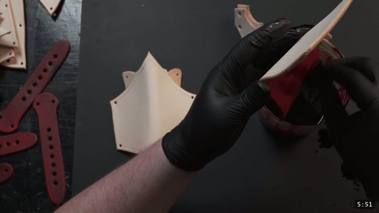 Leather Arm Armor Build Guide: Fantasy Vambrace, Rerebrace, and Elbow 8 applying red dye to an arm-armor piece over a dye container, red-dyed straps resting on the bench