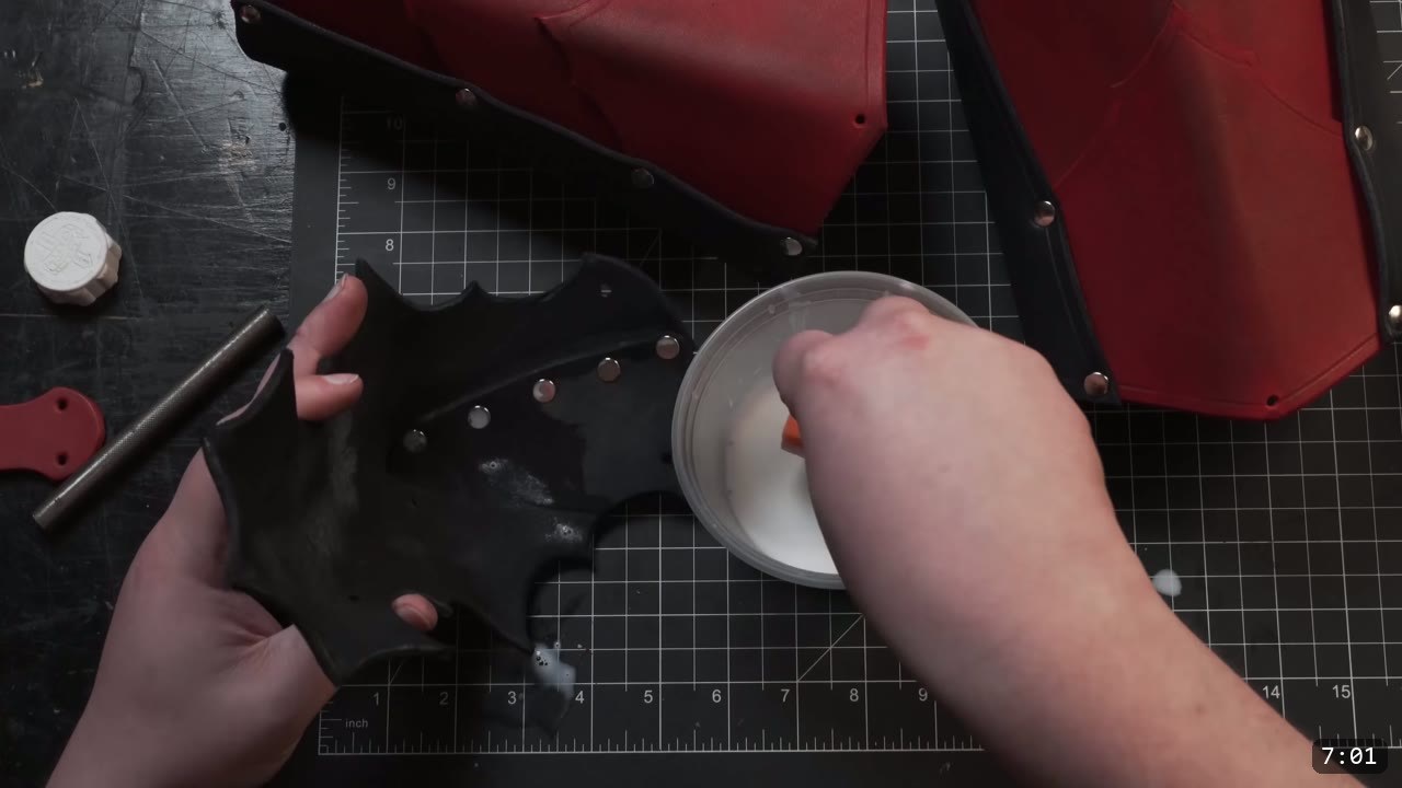 Leather Arm Armor Build Guide: Fantasy Vambrace, Rerebrace, and Elbow 9 sealing a dyed-black elbow piece with a coat of finish from a cup, silver rivets already set, red pieces behind