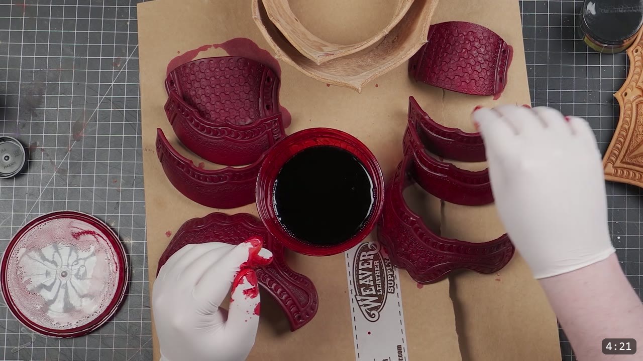 Articulating Leather Gauntlets Build Guide: A Fantasy Set from a Flat Pattern 5 gloved hand dyeing tooled leather cuff and hand pieces deep red around an open container of dark dye on kraft paper