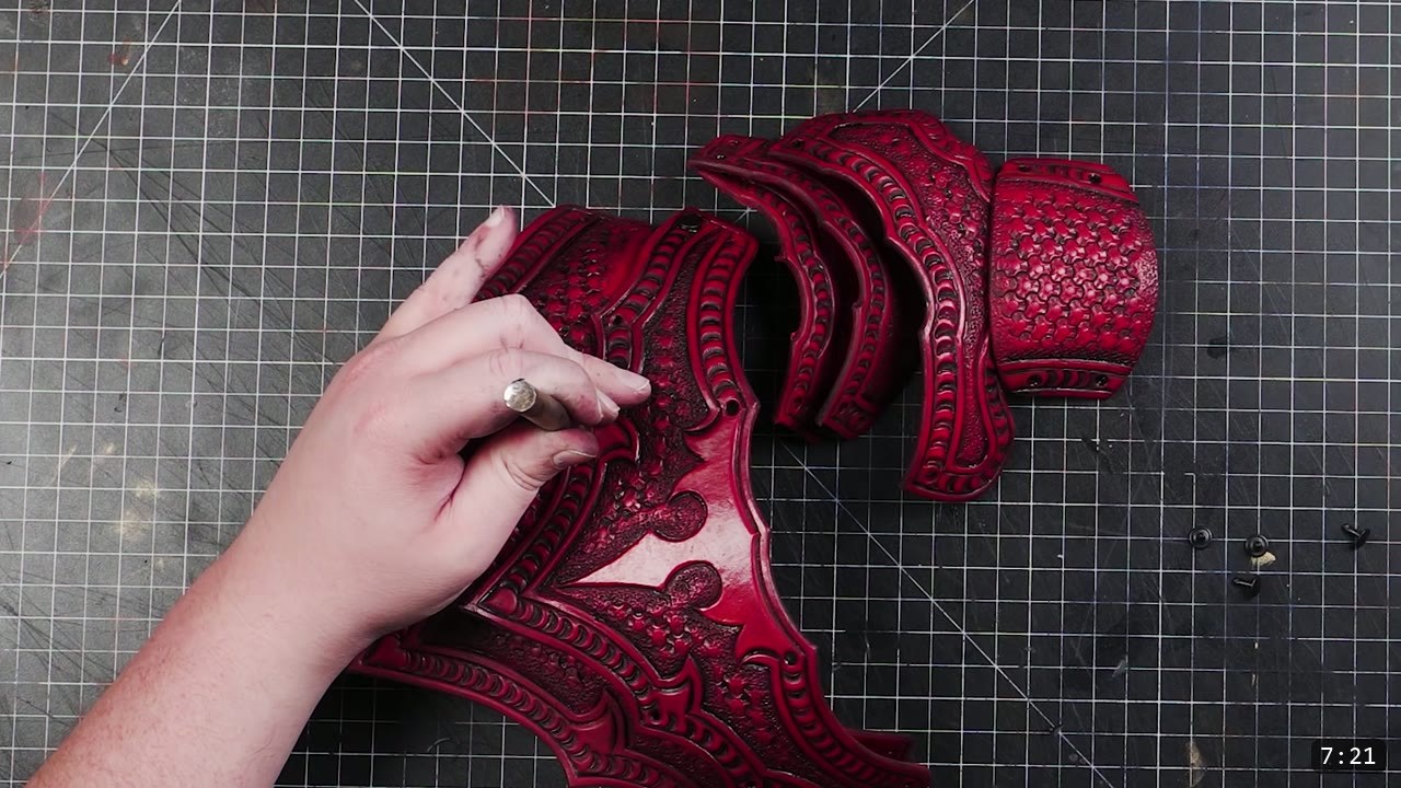 Articulating Leather Gauntlets Build Guide: A Fantasy Set from a Flat Pattern 7 deep red antiqued leather cuff and overlapping hand pieces laid out on a cutting mat with small black rivets nearby