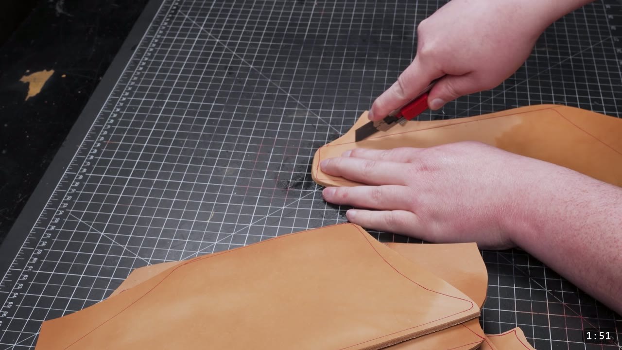 Leather Cuisses and Knees Build Guide: Articulated Upper-Leg Armor 4 cutting a large tan vegetable-tan leg panel along a red marked line with a utility knife on a cutting mat