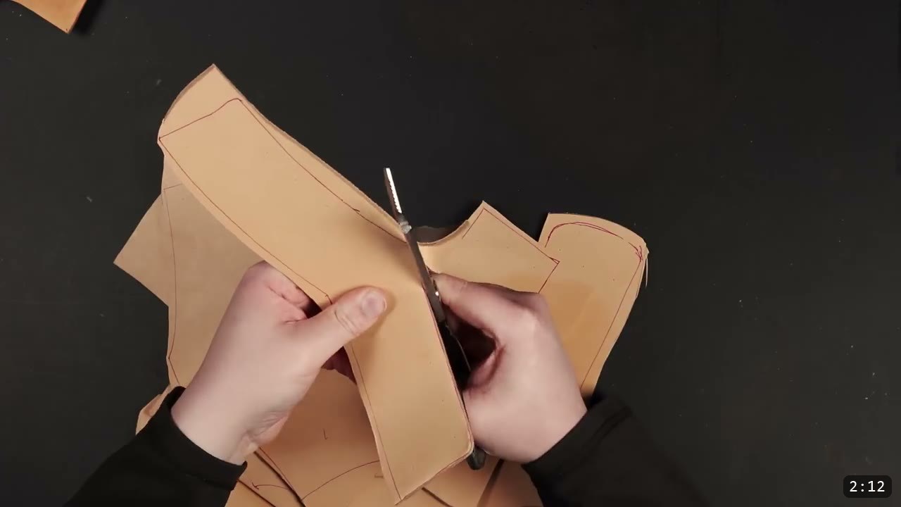 Leather Gorget Build Guide: A Fantasy Armor Neck Guard, Step by Step 5 cutting a tan leather gorget piece with heavy shears along a traced red line on a black work surface