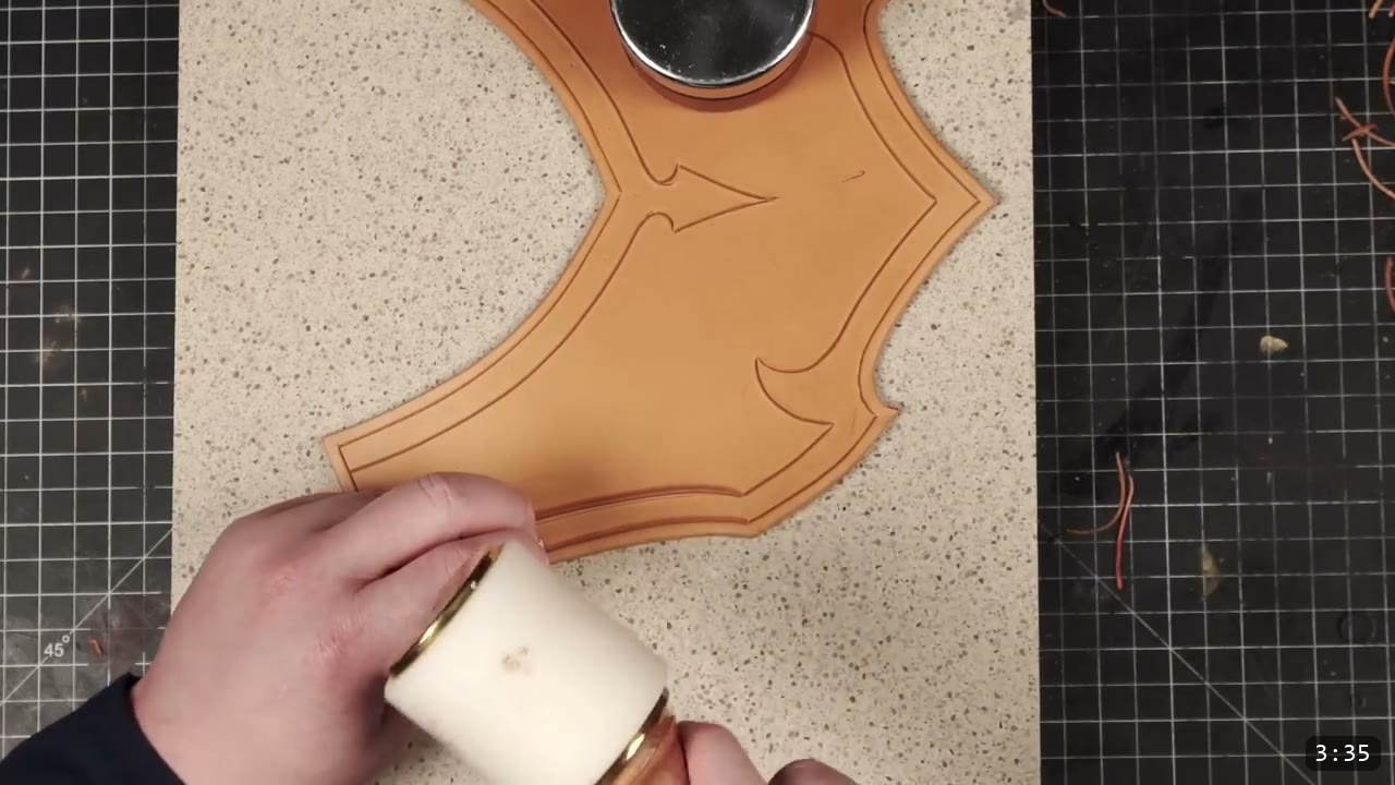 Leather Gorget Build Guide: A Fantasy Armor Neck Guard, Step by Step 8 slicking the edge of a carved tan gorget piece against a round burnishing tool on a granite slab