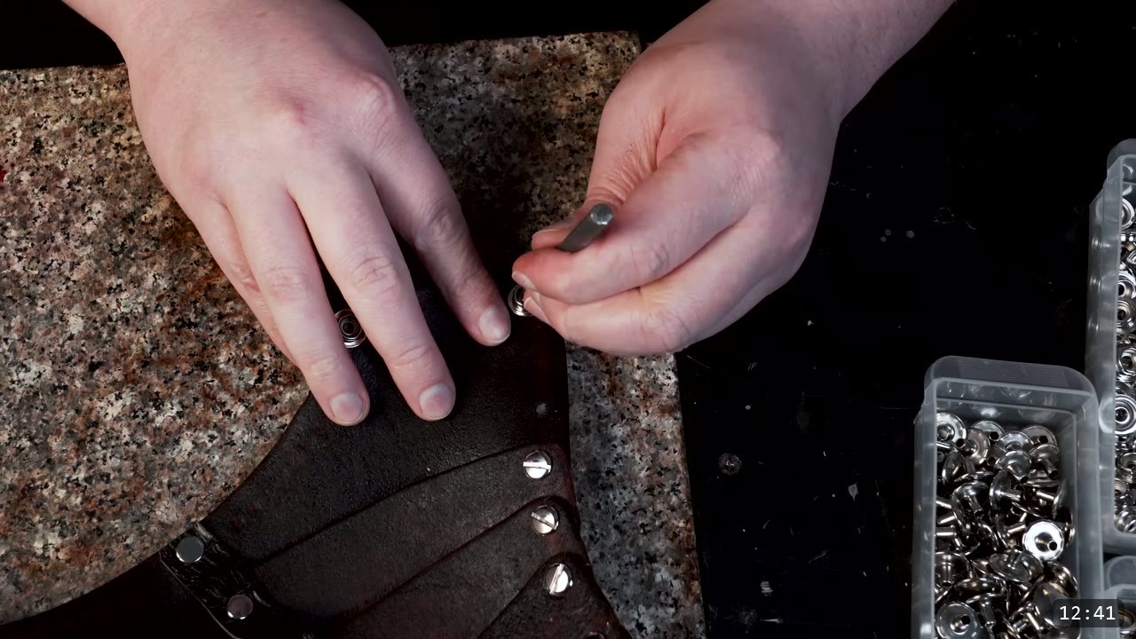 Leather Sabatons Build Guide: Foot Armor from a Flat Pattern 13 setting a snap into the assembled brown sabaton with a hand setter, Chicago screws visible along the lames