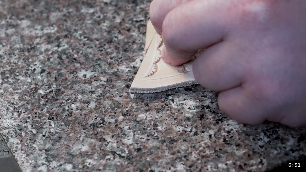 Leather Sabatons Build Guide: Foot Armor from a Flat Pattern 8 burnishing the cut edge of a leather piece that carries a stamped scalloped border, on a granite slab