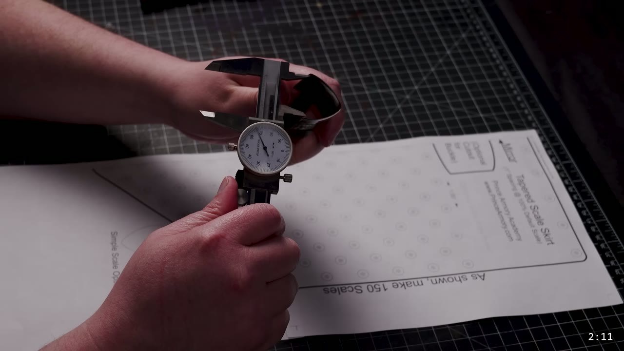 Leather Scale Armor Build Guide: A Flexible Scale Skirt from Scrap Leather 3 a dial caliper held over the printed Prince Armory scale skirt pattern that reads make 150 scales and optional cutout for buckle