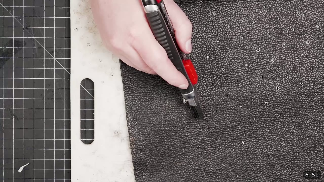Leather Scale Armor Build Guide: A Flexible Scale Skirt from Scrap Leather 8 a snap-blade utility knife cutting the black backing panel against a slab edge with the buckle slot template beside it