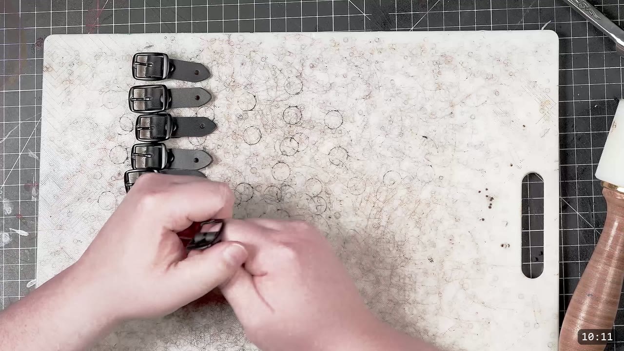 Leather Tassets Build Guide: Fantasy Armor Tassets from a Flat Pattern 11 four black buckle straps laid out, assembling a roller buckle onto a strap on a poly board