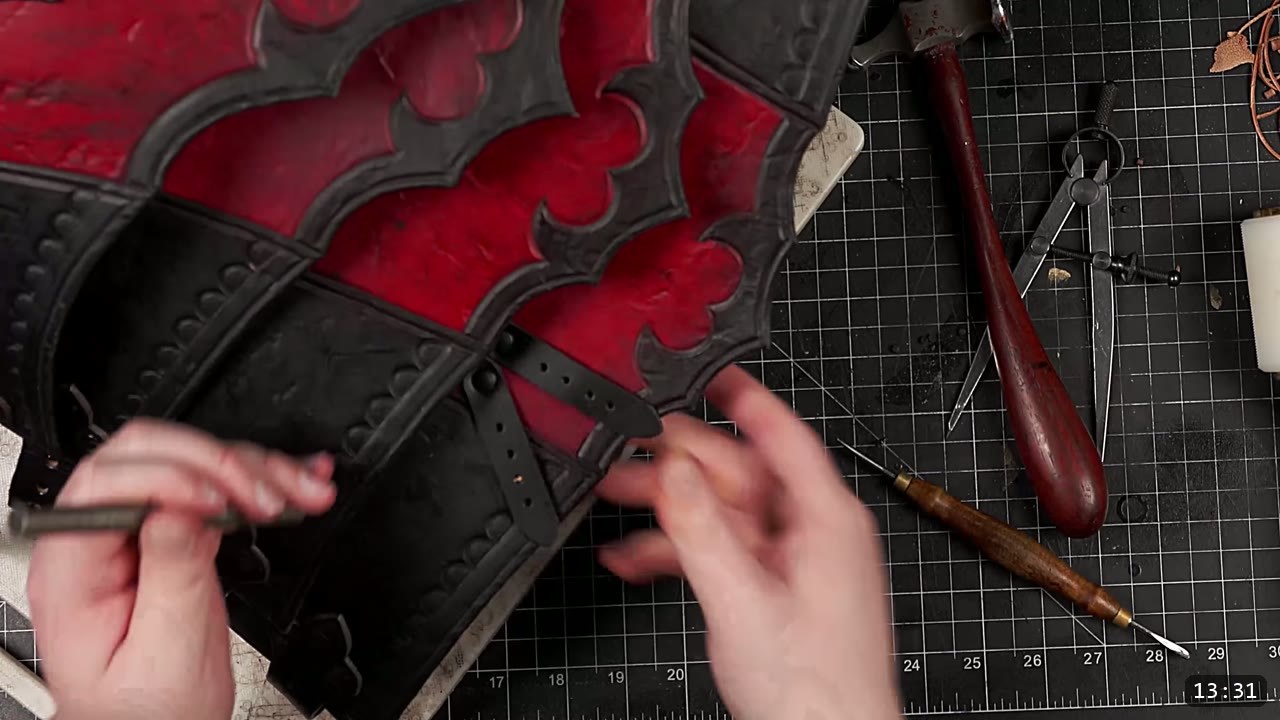 Leather Tassets Build Guide: Fantasy Armor Tassets from a Flat Pattern 14 marking hole positions on the assembled red and black tassets with a scratch awl, dividers and a maul on the mat