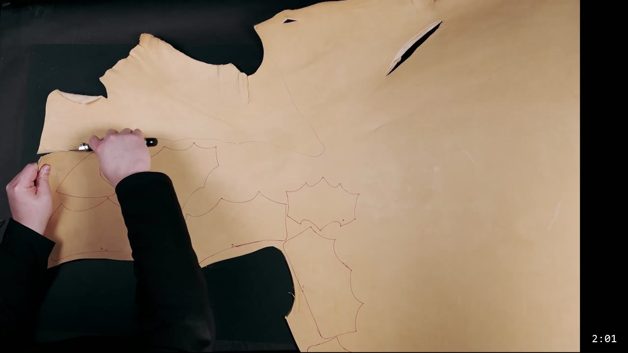Leather Tassets Build Guide: Fantasy Armor Tassets from a Flat Pattern 3 tracing scalloped tasset pattern outlines onto a large piece of natural vegetable-tan leather with a stylus, red pattern lines already marked