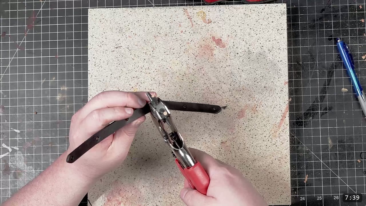 Leather Tassets Build Guide: Fantasy Armor Tassets from a Flat Pattern 9 making a hole in a black leather strap with a force-multiplying handheld hole punch