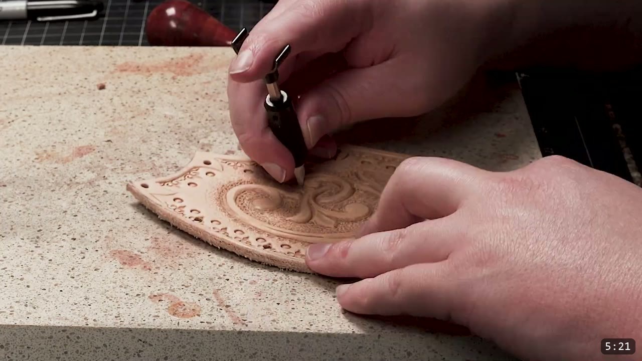 Fantasy Spaulders, Full Suit Version: Leather Shoulders That Mount to the Breastplate 5 a beveling tool working a scroll design on a curved tan plate that already has a punched border, worked on a granite slab