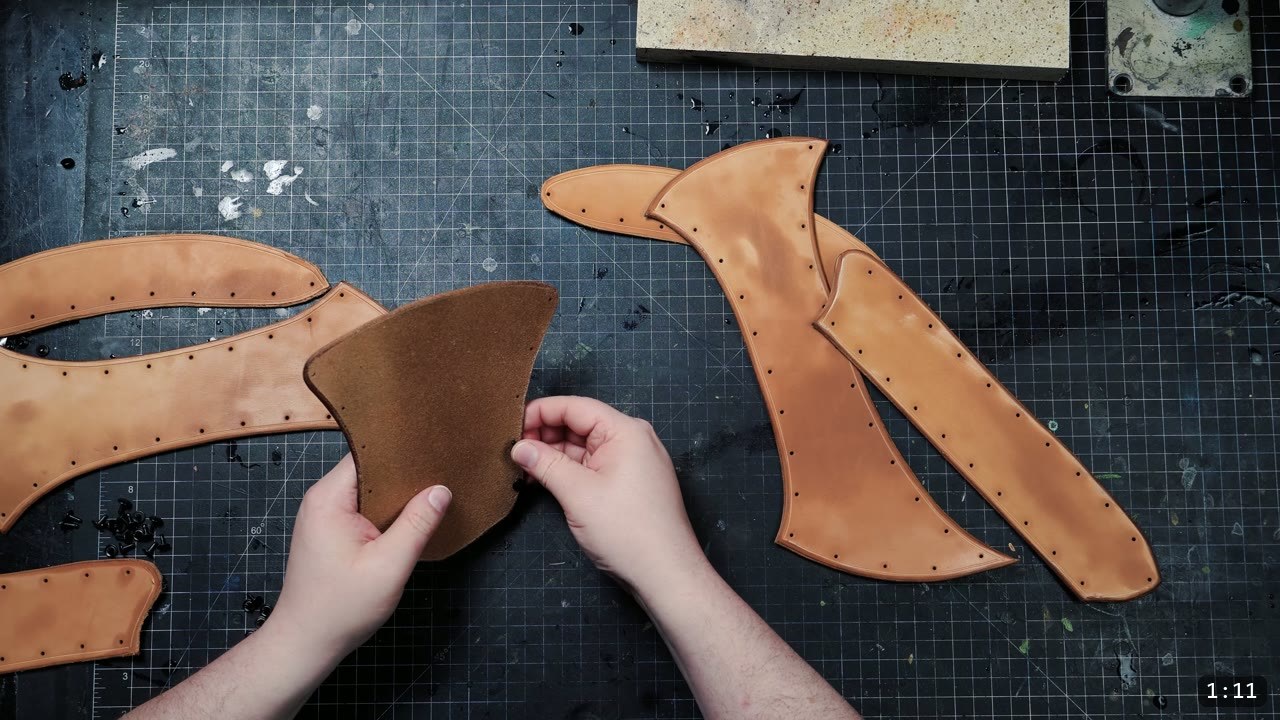 Leather War Belt and Skirting Build Guide: A Fantasy Armor Waist from a Pattern 4 hands holding a cut vegetable-tan belt panel flipped to its suede flesh side, other grooved and beveled panels laid out nearby