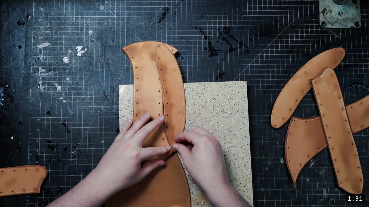 Leather War Belt and Skirting Build Guide: A Fantasy Armor Waist from a Pattern 5 pressing and aligning two damp vegetable-tan belt straps on a granite slab, more punched panels waiting to the side