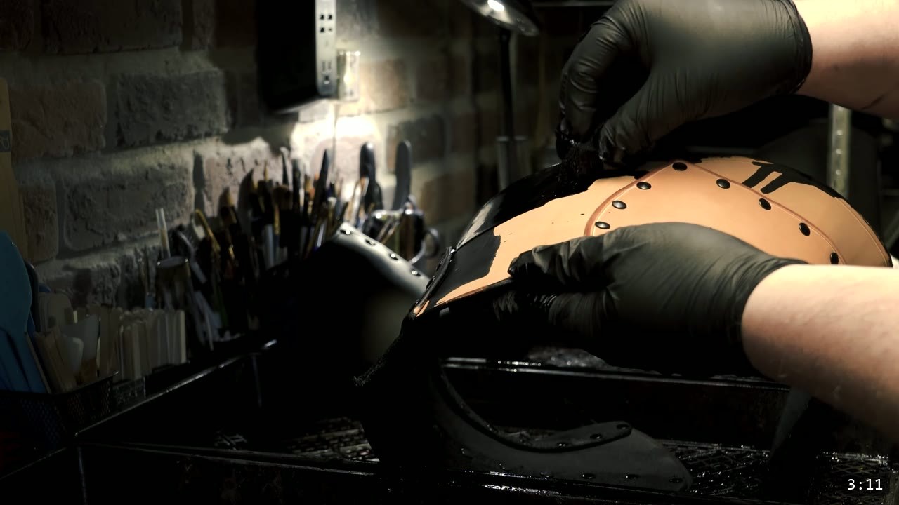 Leather War Belt and Skirting Build Guide: A Fantasy Armor Waist from a Pattern 8 gloved hands working black oil dye into a tan war belt panel over a dye tray, brushes on a rack behind