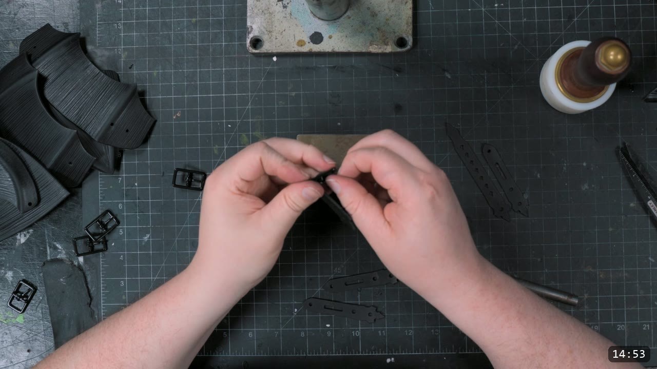 Finishing the Leather Berserk Armor: The Breastplate and Tassets Build Guide 13 assembling the small buckle straps that suspend the back tassets, with roller buckles and numbered straps on the bench