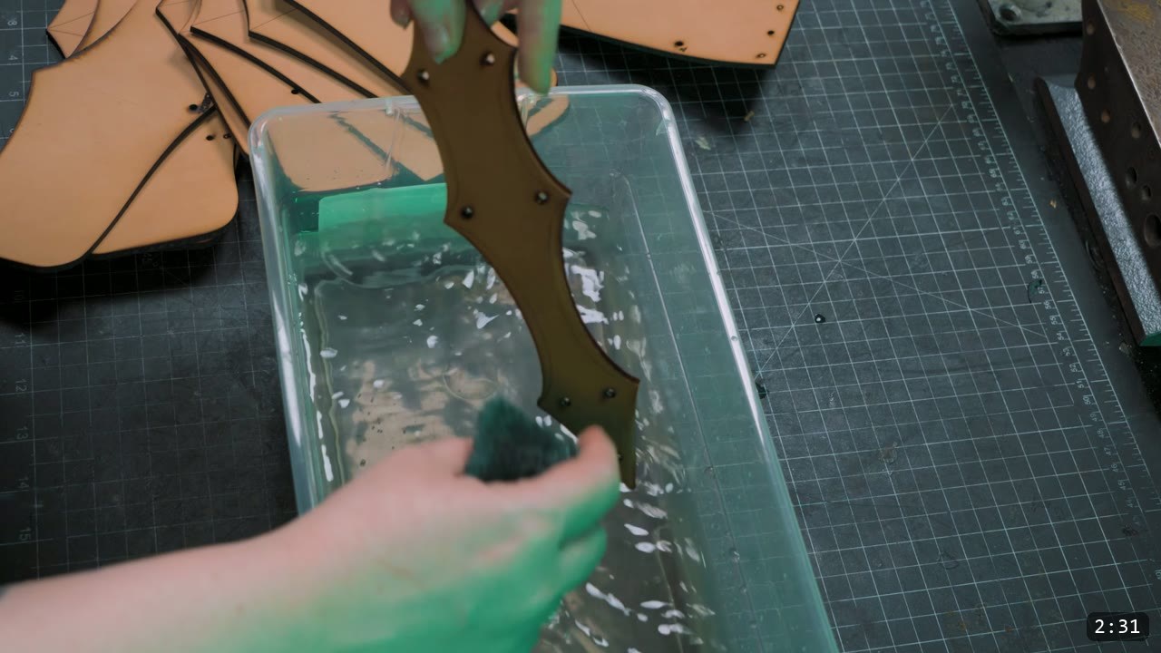 Finishing the Leather Berserk Armor: The Breastplate and Tassets Build Guide 4 scrubbing a freshly cut leather piece with a sponge over a tray of water to clean the edge and wet the leather