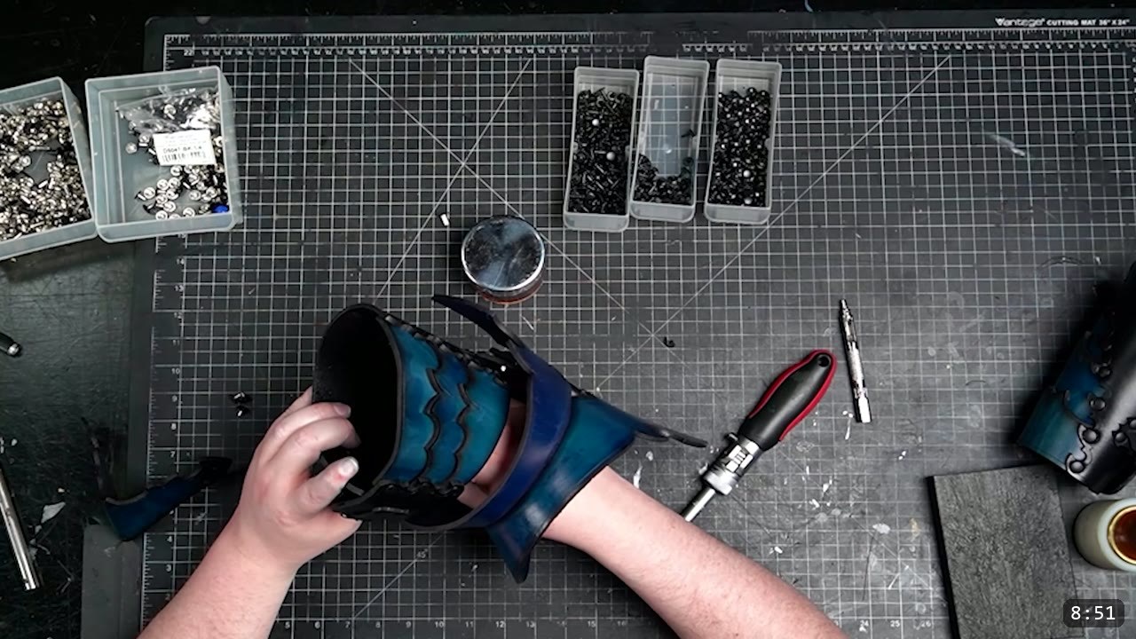 Articulated Leather Arm Armor Build Guide: The Imperial Knight Arms 11 an assembled blue-and-black leather cannon slid onto the forearm to check fit, with a second finished cannon on the bench