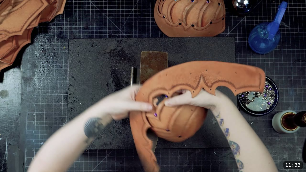 forming and riveting a tooled cup piece into its curved three-dimensional shape over an anvil, iridescent rivets set along the seams