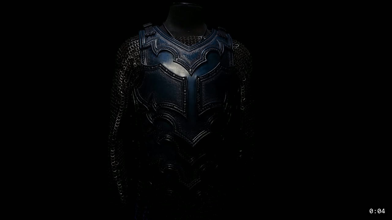 Leather Breastplate Build Guide: The Imperial Knight, Cut by Hand 2 finished Imperial Knight leather breastplate on a display form, blue-black tooled front panels over a mail shirt, in dramatic low light