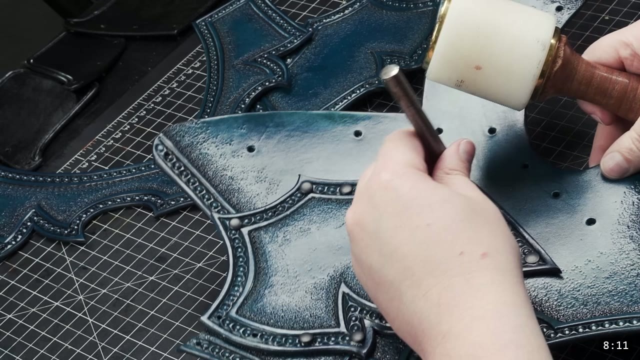 Leather Breastplate Build Guide: The Imperial Knight, Cut by Hand 11 setting a rivet on the dyed blue-black chest panel with a setter and a poly mallet on a raised surface