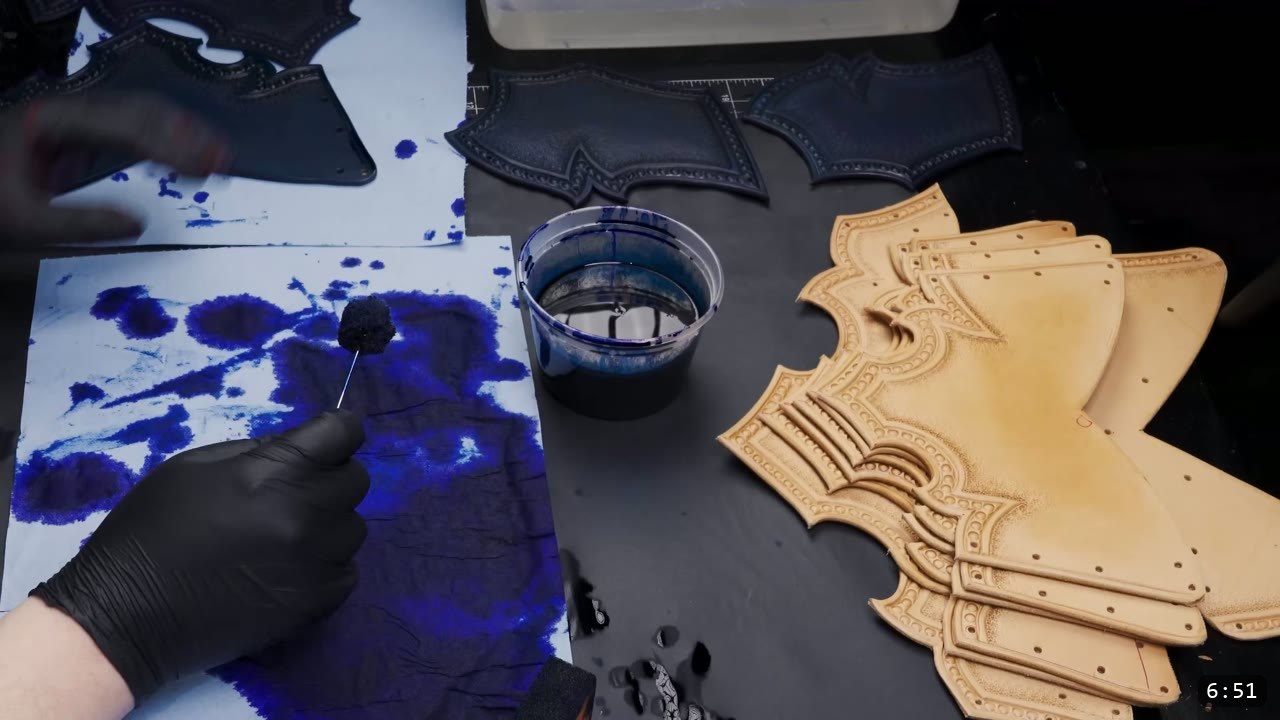 Leather Breastplate Build Guide: The Imperial Knight, Cut by Hand 10 testing blue leather dye on scrap paper with a dauber, a cup of blue dye and tooled natural panels waiting to be colored