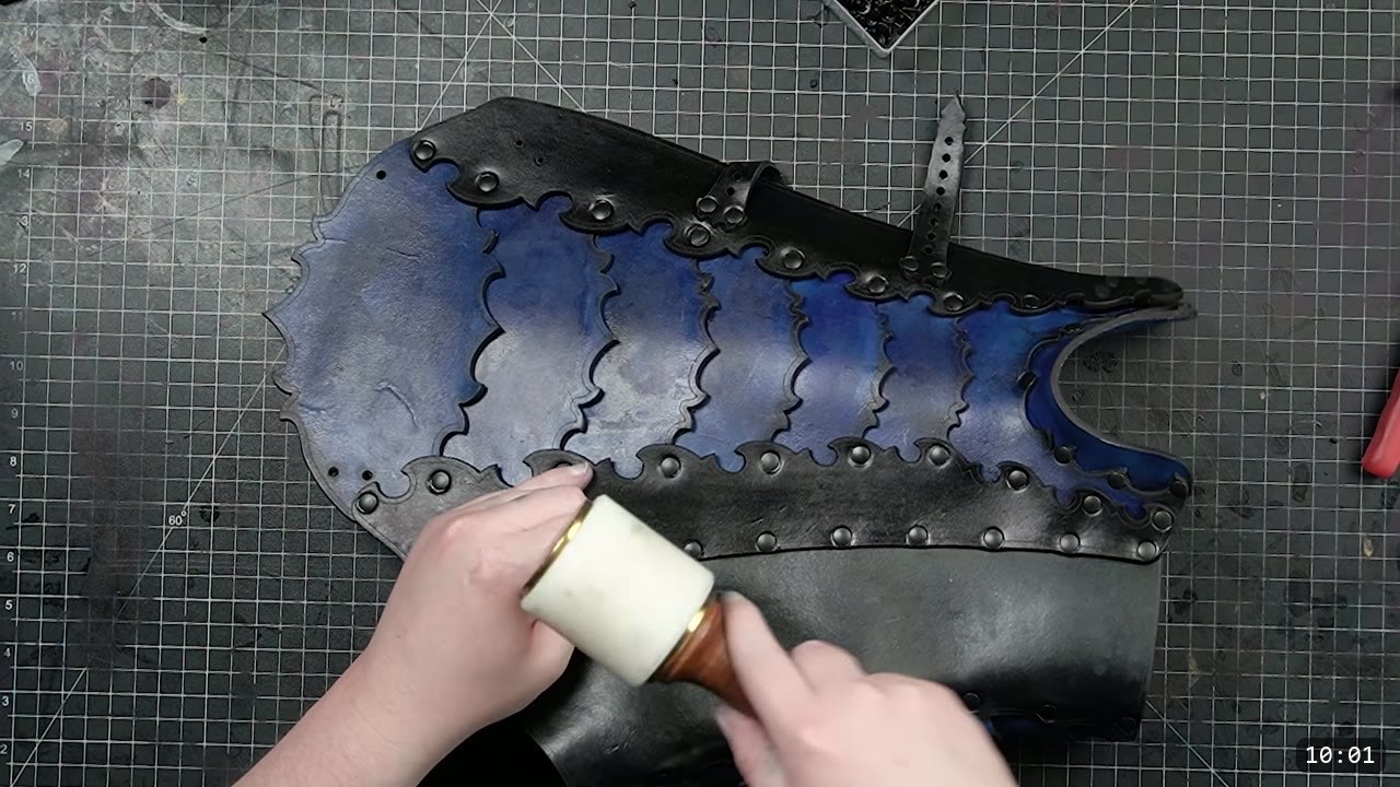 Leather Greaves Build Guide: Imperial Leg Armor from a Flat Pattern 12 the finished flat greave back section, black outer frame with blue lamellar scallops and a buckle strap, fully riveted