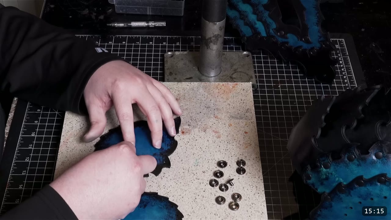a dyed leather piece held on a granite slab with snap caps and sockets laid out ready to set
