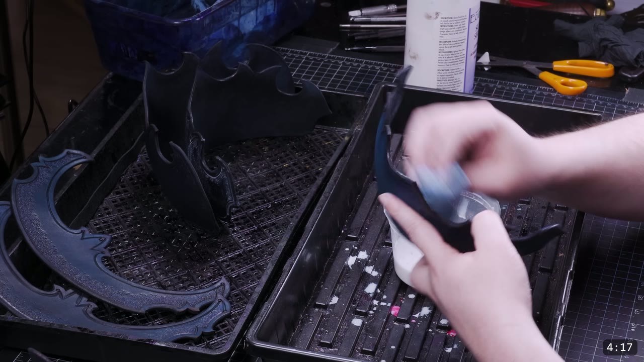 applying finish with a sponge to a black-dyed lame, more dyed lames drying on graded drip trays