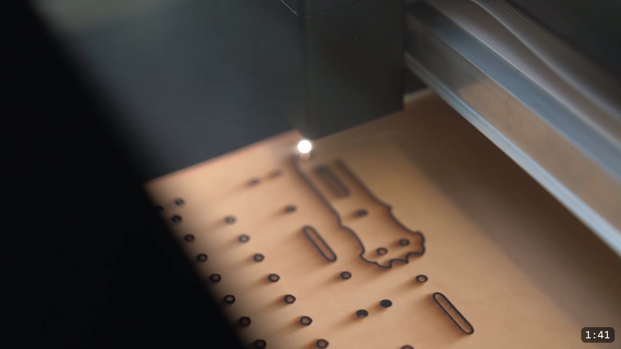 Imperial Knight Tassets Build Guide: Leather Hip Armor from a Flat Pattern 4 a laser cutter head cutting the outline and a row of round and slotted holes into natural tan leather
