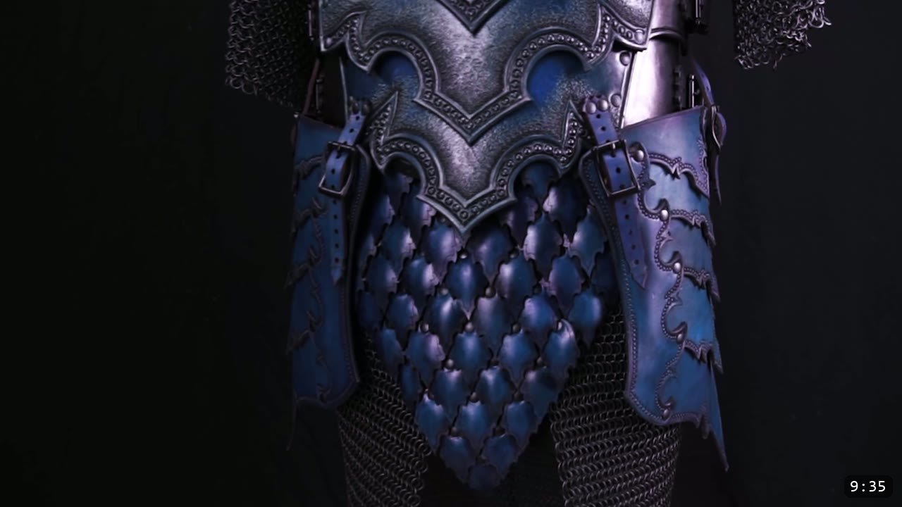 Leather Scale Skirting Build Guide: Laser-Cut Scales into a Modular Armor Skirt 3 a royal-blue leather scale skirt hanging from an ornate blue-black tooled breastplate, flanked by buckled tassets, over chainmail on a black background