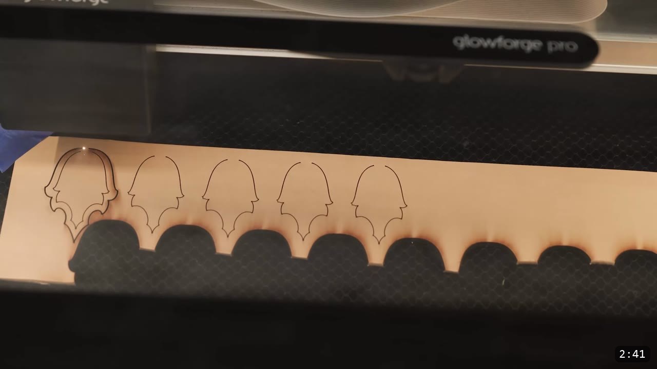 Leather Scale Skirting Build Guide: Laser-Cut Scales into a Modular Armor Skirt 5 a close-up of a Glowforge Pro cutting a strip of tan leather on the honeycomb bed, five pointed scale silhouettes cut into it with a scalloped edge