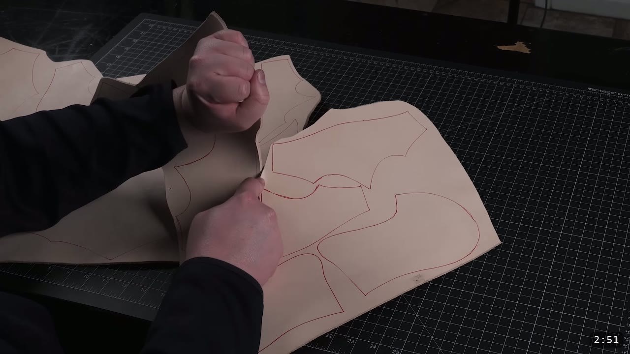 Leather Armor for Beginners: Tools You Need and How to Start 4 a black stone tooling slab resting on a granite base on a wood workbench, with a cut veg-tan leather piece alongside