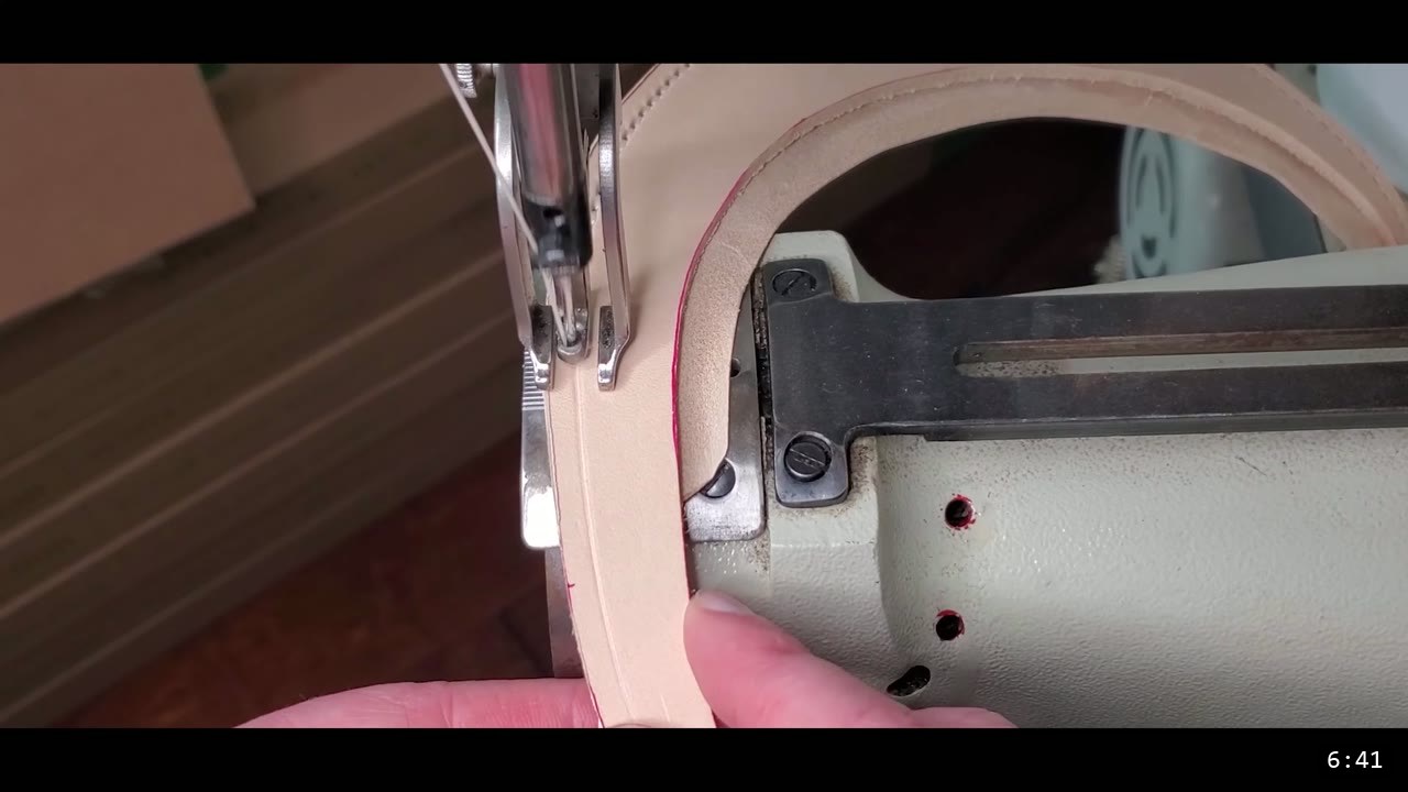 The Mountain Leather Helmet Build Guide: A Free Pattern, Start to Finish 7 a curved tan leather crest piece with a red guideline running under the needle of a heavy-duty leather sewing machine