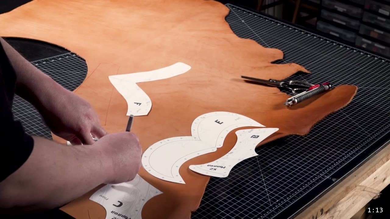 Leather Warrior Helmet Build Guide: Flat Pattern to Finished Piece 2 hand tracing lettered paper helmet pattern pieces onto a natural vegetable-tan leather hide on a cutting mat, shears resting to the side