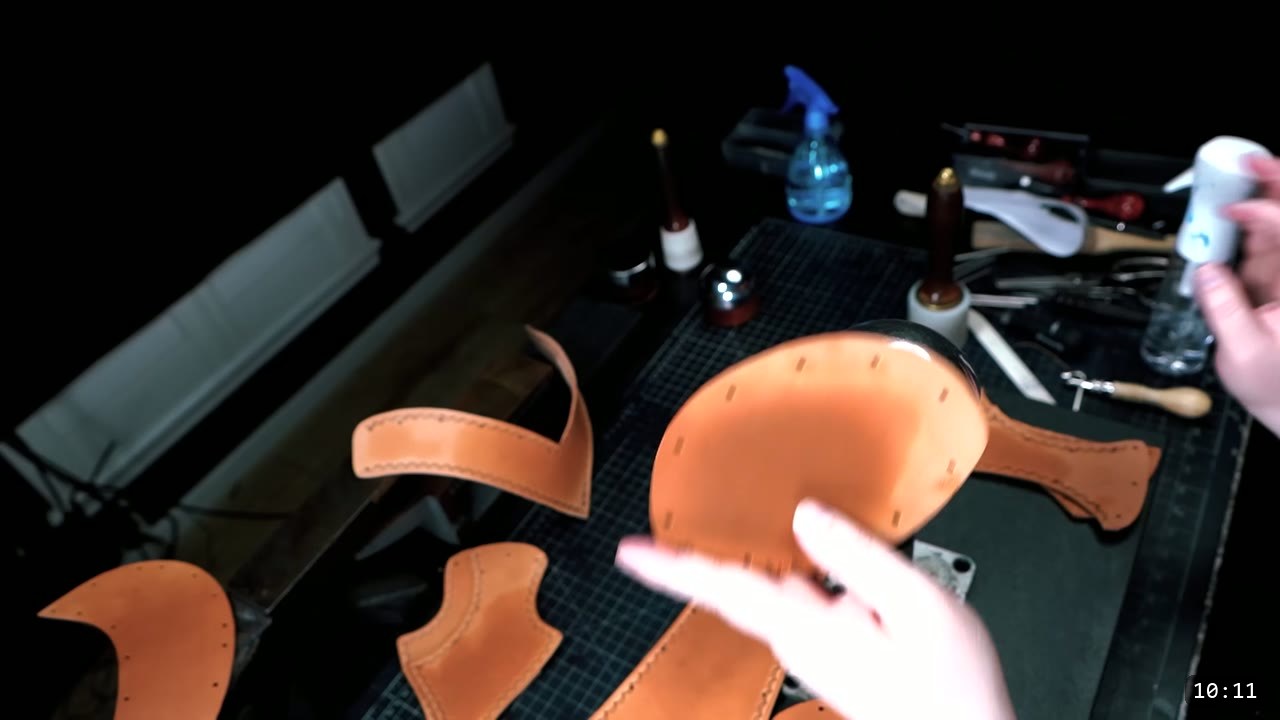 Leather Warrior Helmet Build Guide: Flat Pattern to Finished Piece 7 stretching a damp tan leather top piece over a shiny metal dome stake, cut pieces and dye bottles on the bench