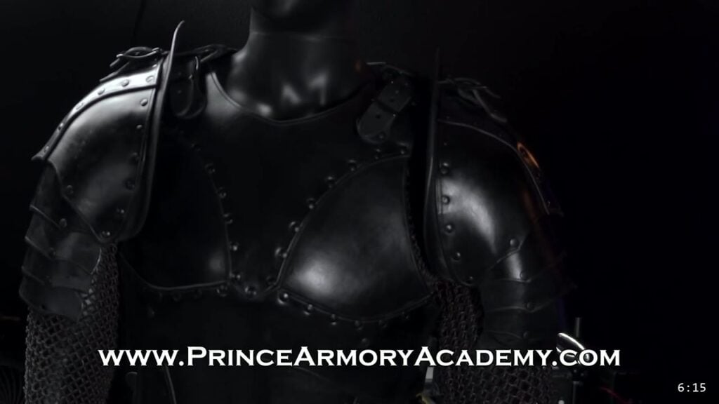 the finished black leather warrior armor on a mannequin, both pauldrons mounted over chainmail sleeves